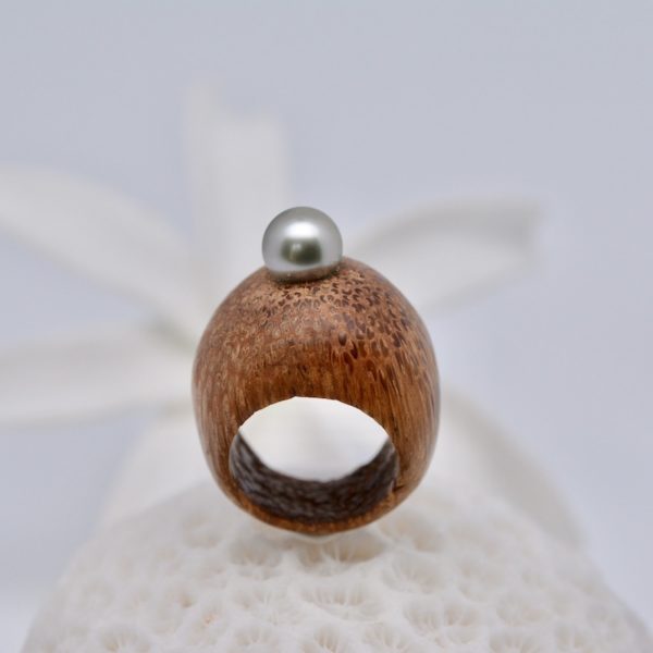 Voici une très originale bague taillée dans du bois de cocotier et ornée d'une véritable perle de Tahiti de qualité A