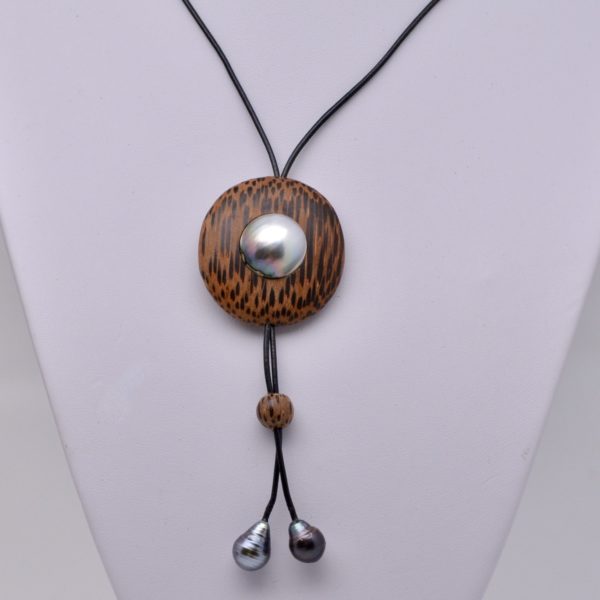 Voici Hakaiki, un collier d'une grande originalité, une pièce unique.Il associe l'essence de cocotier, si cher au cœur des polynésiens, le mabe et la perle de Tahiti. Un collier ajustable grâce à une bille de cocotier et terminé par deux véritables perles de Tahiti Bien sûr les perles et le mabe ont été produit par mes soins sur ma ferme perlière de Tahiti.