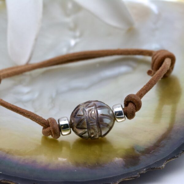 Aitu est bracelet en cuir réglable et une perle gravée semi-baroque de 12,5 mm qualité A rehaussé d'intercalaires en argent.