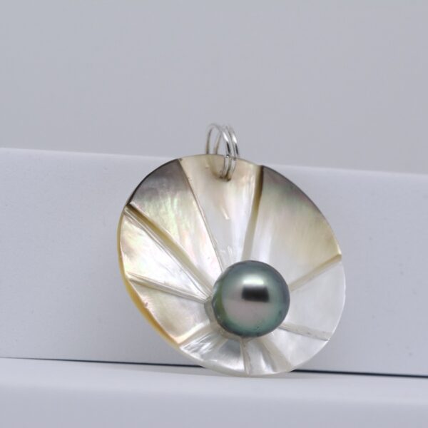 Kimi un pendentif perle de Tahiti ronde Un médaillon de nacre dorée gravée et une perle de culture verte de 9mm issue de ma ferme perlière de Manihi. En v ente directe