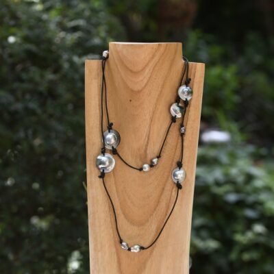 Long de 130 cm, ce sautoir en cuir de vache noir associe harmonieusement 10 grosses perles de Tahiti cerclées et 5 impressionnants mabe de Tahiti, double pour un rendu unique, à la fois audacieux et naturel. Chacune des 10 perles sélectionnées pour ce bijou provient directement de ma ferme perlière artisanale de Manihi, dans l’archipel des Tuamotu.