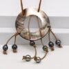 Collier Rikitea avec 8 perles de Tahiti cerclées et pièce centrale en nacre sculptée, montage cuir artisanal – création unique de Tahiti Perles Création
