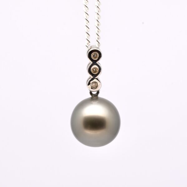 Pendentif Kamali avec perle de Tahiti ronde 11,8 mm qualité A, monté sur or gris 18k et orné de 3 diamants. Création artisanale unique.