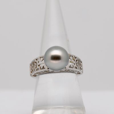 Je vous présente Papape, une bague en argent 925 rhodié gravée de motifs marquisiens traditionnels, qui accueille une perle de Tahiti exceptionnelle. Cette perle ronde de 9,5 mm révèle une couleur blanc nacré rare et naturelle, éclatante de pureté et de douceur. Son nom, Papape, signifie « blanc » en tahitien, un clin d’œil à cette teinte lumineuse et précieuse que seule l’huître perlière Pinctada margaritifera peut produire dans certaines conditions spécifiques.