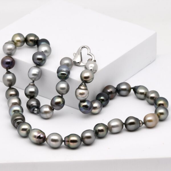 Collier Tetae, 41 perles de Tahiti semi baroques et cerclées de 10 à 11 mm, couleurs naturelles, monté avec nœuds et fermoir cœur en argent rhodié.