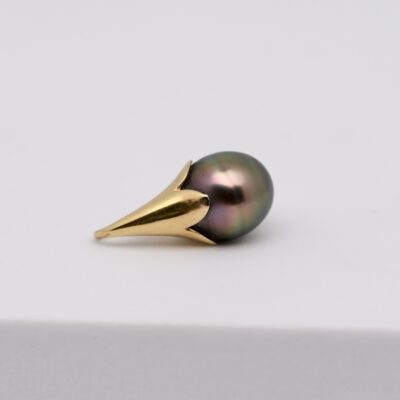 Ce pendentif perle Haehae est une pièce de joaillerie artisanale montée en or jaune 750/1000 (18 carats). Il accueille une perle de Tahiti en forme de goutte, classée qualité B, mesurant 9 mm. Cette perle présente une couleur très soutenue, avec des reflets naturels qui varient selon l’angle de la lumière.