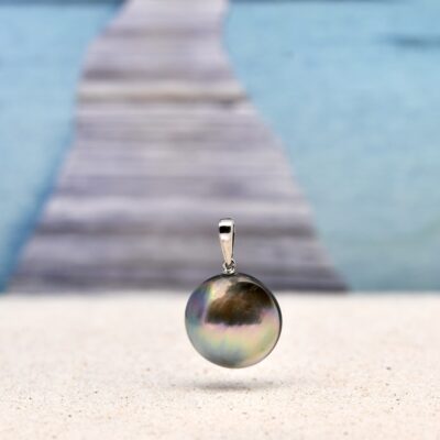 Dans les profondeurs limpides du lagon de Manihi, une huître a patiemment façonné un joyau coloré : un mabe aux reflets envoûtants, capturant la lumière comme les souvenirs d’un coucher de soleil polynésien. 