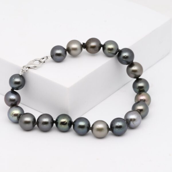 Dans la tradition polynésienne, chaque perle raconte une histoire, chaque bijou révèle un lien entre la nature et l’artisan. Le bracelet perles Anuenue, qui signifie "arc-en-ciel" en langue hawaïenne, incarne cette fusion parfaite entre éclat naturel et savoir-faire artisanal. Composé de 18 perles de Tahiti rondes de 9 à 10 mm, ce bracelet séduit par sa palette de couleurs naturelles, allant du vert intense au gris bleuté.