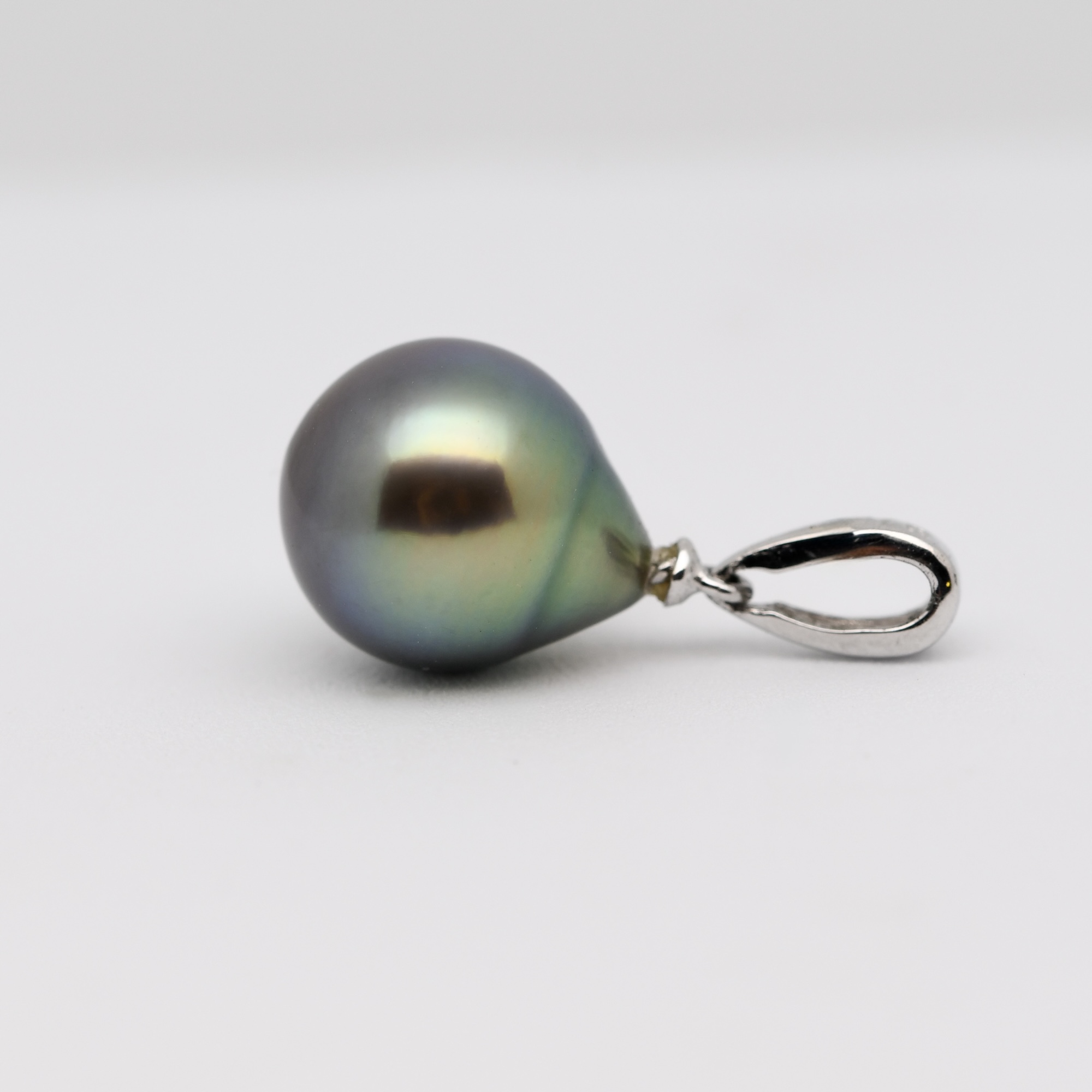 La couleur de cette perle est exceptionnelle : un vert tilleul lumineux qui évolue en un bleu sombre intense à sa base. Cette variation naturelle, propre à la Pinctada margaritifera, offre une profondeur chromatique rare. Selon l’éclairage, la perle change d’expression : parfois douce et végétale, parfois profonde et marine. Ce jeu de nuances est entièrement naturel — aucune teinte, aucun traitement, seulement la magie du lagon.