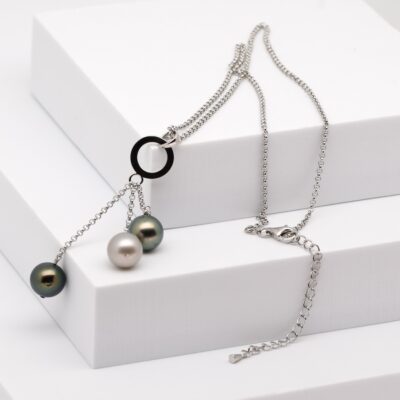 Photo du collier Toru : un collier en argent 925 rhodié composé de trois perles de Tahiti rondes de 9,8 mm, aux couleurs naturelles et au lustre excellent. Les perles sont alignées harmonieusement au centre d’une chaîne fine de 42 cm, complétée par une chaîne de réglage de 5 cm. L’ensemble présente un style épuré, équilibré et élégant, typique de la bijouterie polynésienne, avec des perles produites sur la ferme perlière de Manihi et montées artisanalement à Marseille.