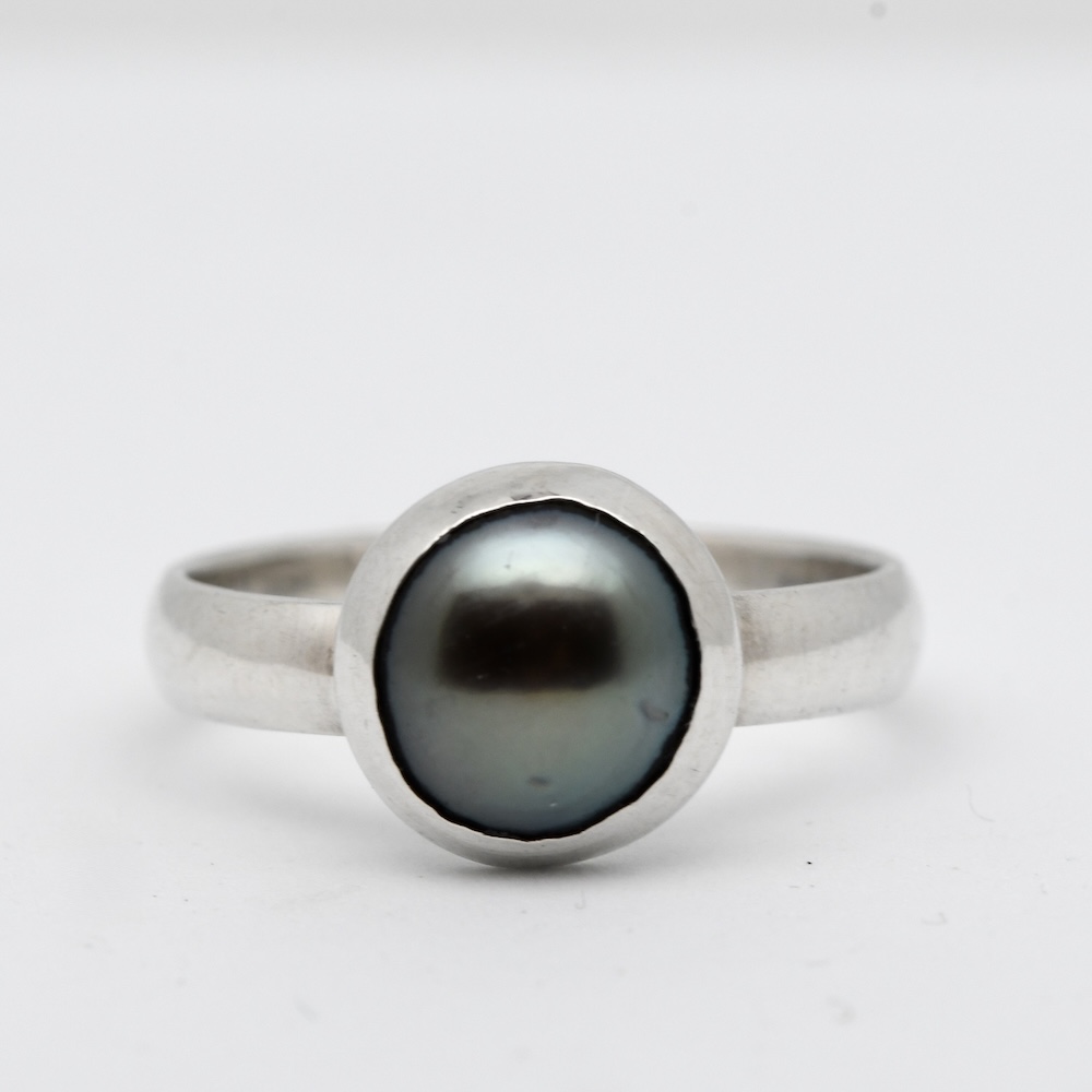 Cette bague perle de Tahiti Keala se distingue par son esthétique épurée : un anneau en argent 925 qui souligne sans artifices la beauté brute de la nacre. Le choix d’un design minimaliste permet de concentrer toute l’attention sur la perle, véritable cœur du bijou. Chaque bague perle de Tahiti Keala est une pièce unique, façonnée à la main, ce qui lui confère une identité propre et un caractère authentique.