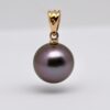 Le pendentif perle Kaloke (Rose en Hawaien) est en or jaune 18 k qui met en lumière une superbe perle de Tahiti ronde de 10,1 mm, sélectionnée pour sa qualité et surtout pour sa couleur violine exceptionnelle, subtilement enrichie de nuances de vert profond. Cette combinaison de teintes naturelles offre un rendu visuel fascinant, oscillant entre reflets pourpres et éclats végétaux, selon l’intensité de la lumière.