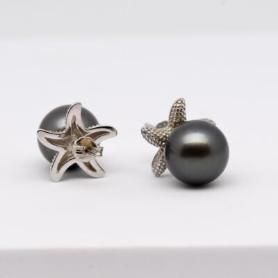 Les boucles d’oreilles perles Hoku sont une invitation directe au voyage au cœur des lagons polynésiens. Leur design original en forme d’étoiles de mer évoque immédiatement les fonds marins cristallins de Manihi, où sont produites les véritables perles de Tahiti qui composent ce bijou.